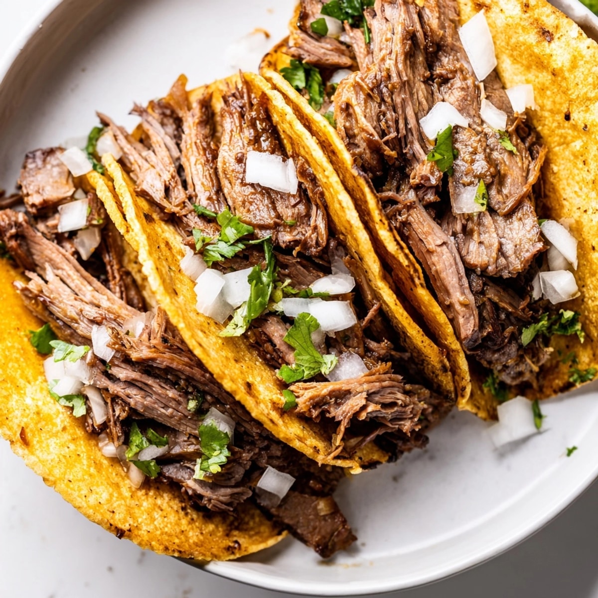 Close up of flavorful and tender Crock Pot Carne Asada Street Tacos, ready to serve.