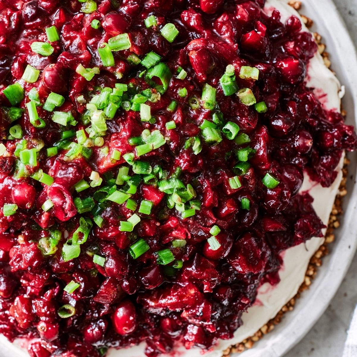 Sweet and spicy Cranberry Jalape&amp;ntilde;o Dip, ready to be scooped up with golden crackers.