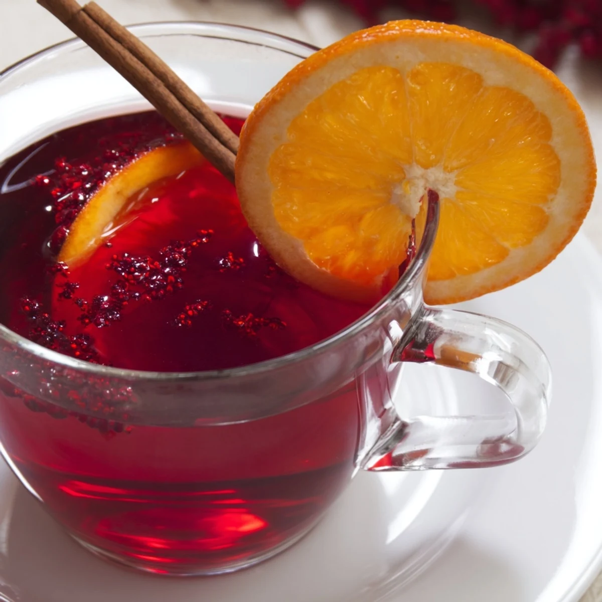 Steaming Cranberry Tea pictured, garnished with orange slices; perfect warm drink for any gathering.