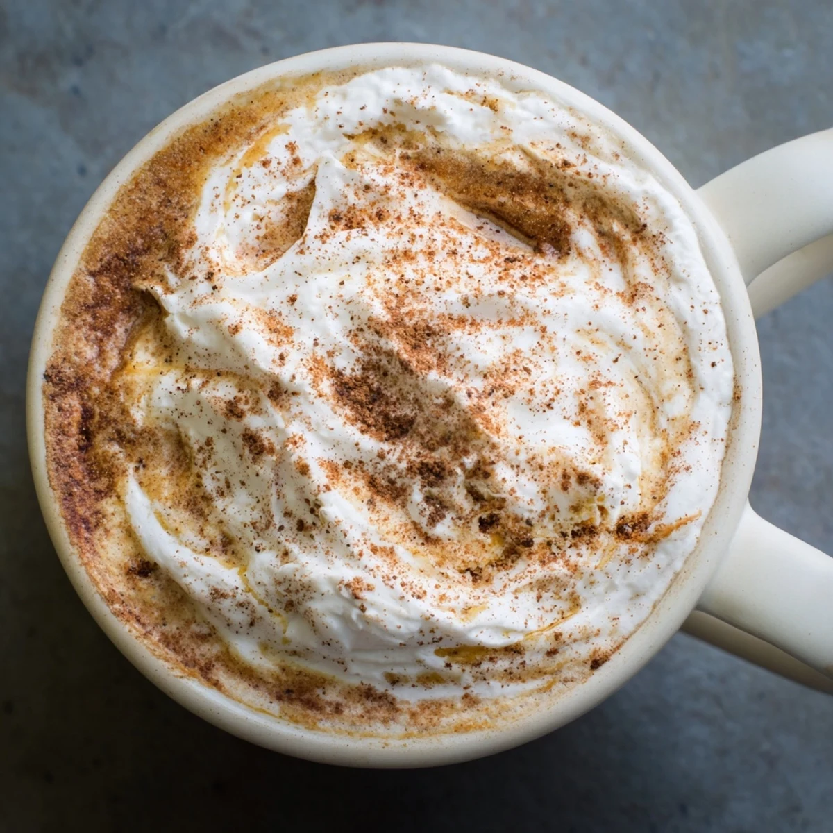 Steaming Gingerbread Spiced Latte topped with whipped cream, perfect for a festive treat.