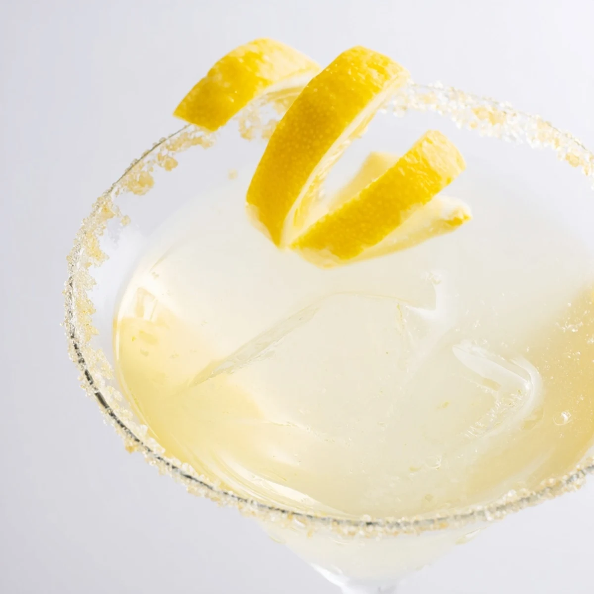 Golden-hued Drop Lemon cocktail, a refreshing mix of vodka, citrus, and ice, ready to sip.