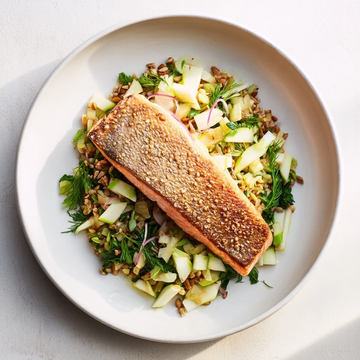 Golden, crispy skin salmon served atop vibrant fennel slaw, a delicious and easy meal.