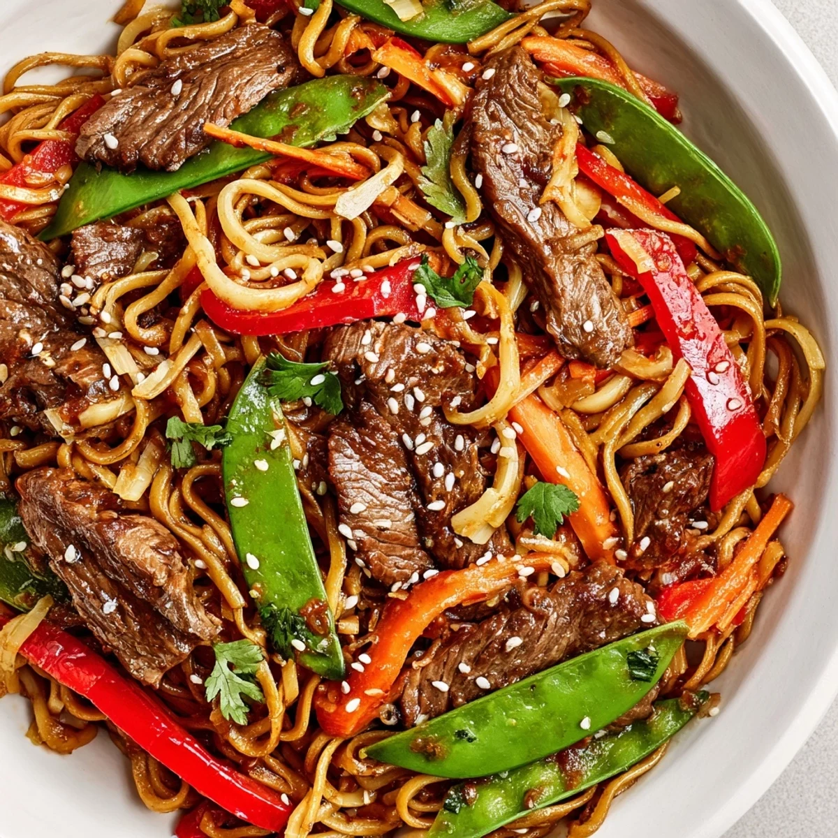 Delicious serving of Spicy Beef Noodles topped with sesame seeds and cilantro, ready to enjoy hot.