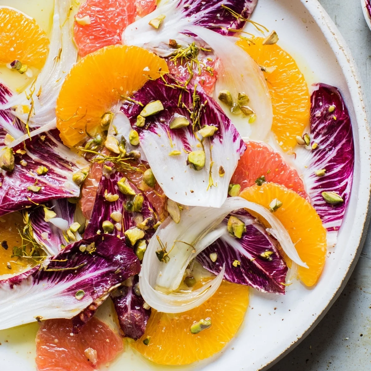 A vibrant platter of Winter Citrus Salad with Radicchio and Fennel featuring juicy orange and grapefruit rounds with fennel fronds.