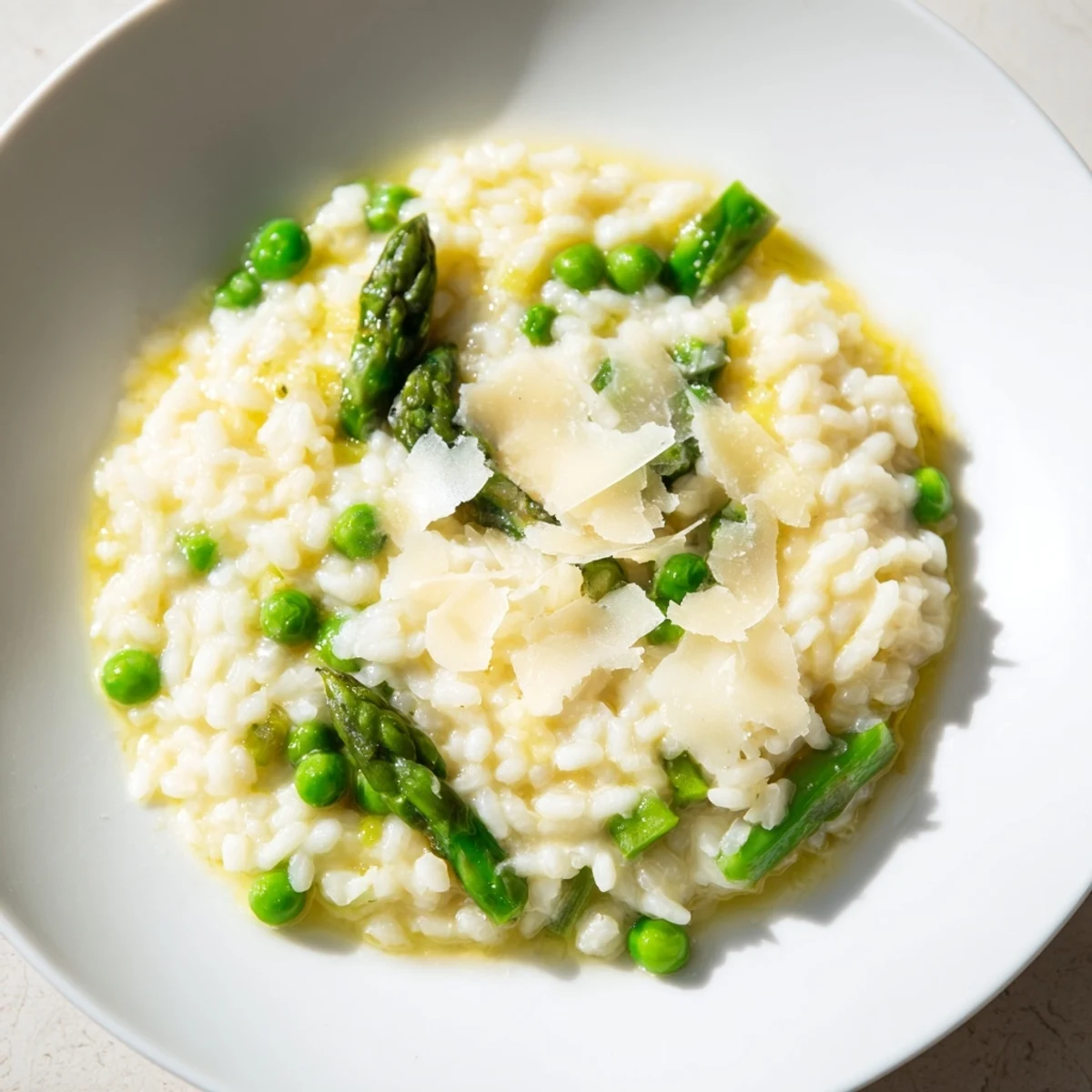 Spoon lifting a serving of creamy asparagus and pea risotto, revealing a rich, velvety texture.