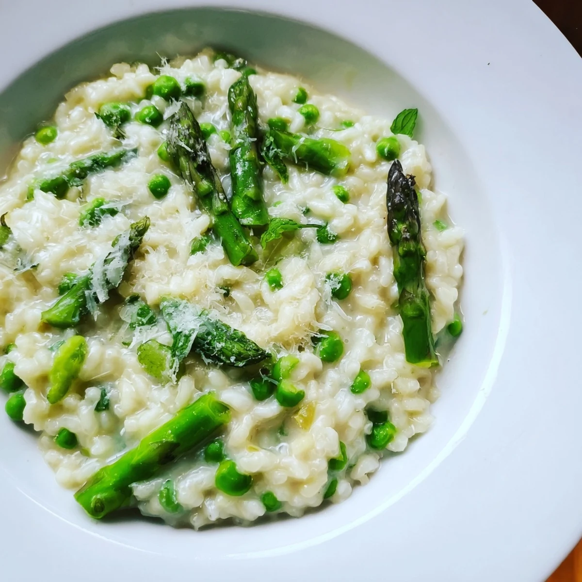 Enjoy this Creamy Asparagus and Pea Risotto with Mint as a perfect spring main course, garnished with bright mint leaves and a drizzle of olive oil.