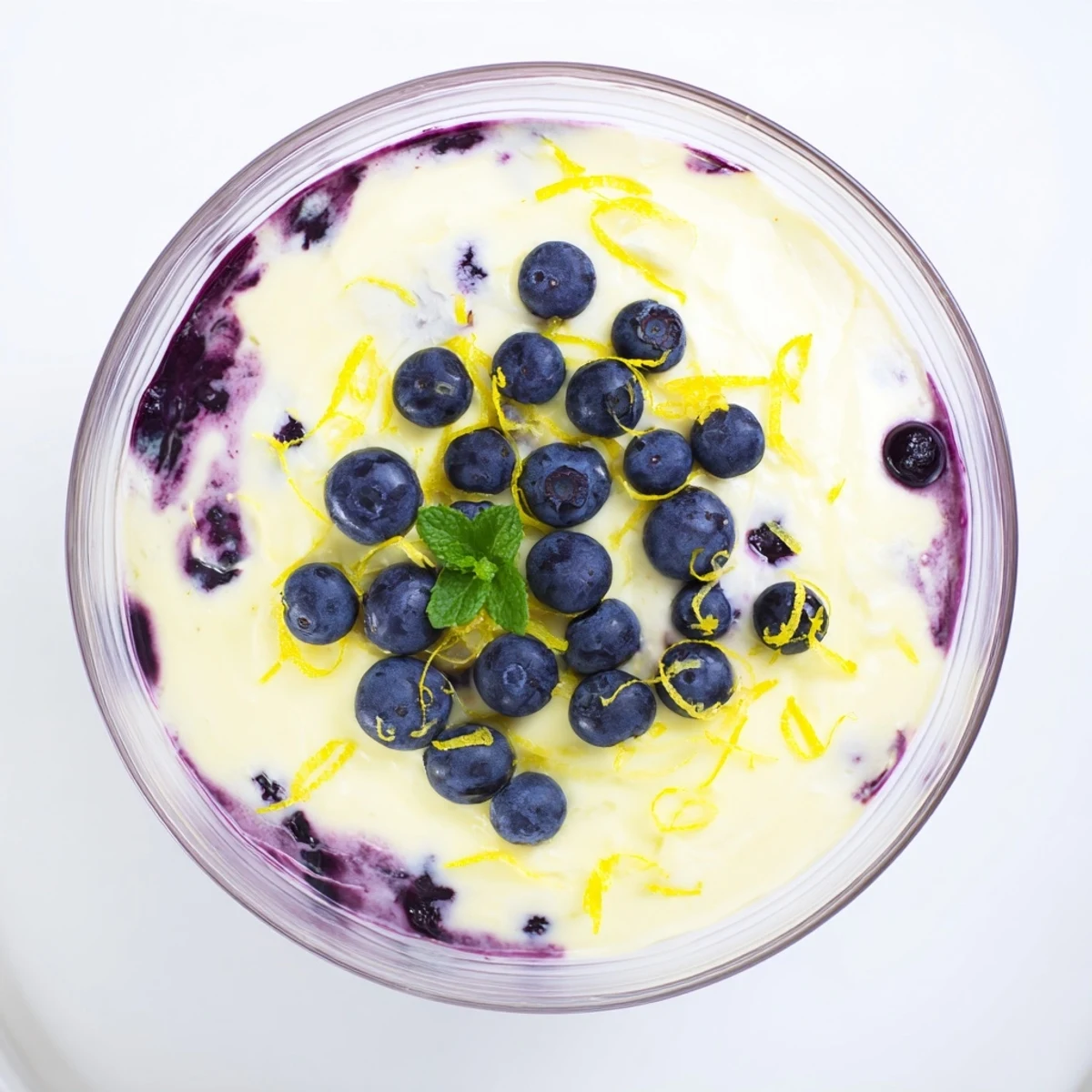 Delicate Lemon Blueberry Mousse in clear glass with fresh berries and mint garnish, perfect dessert