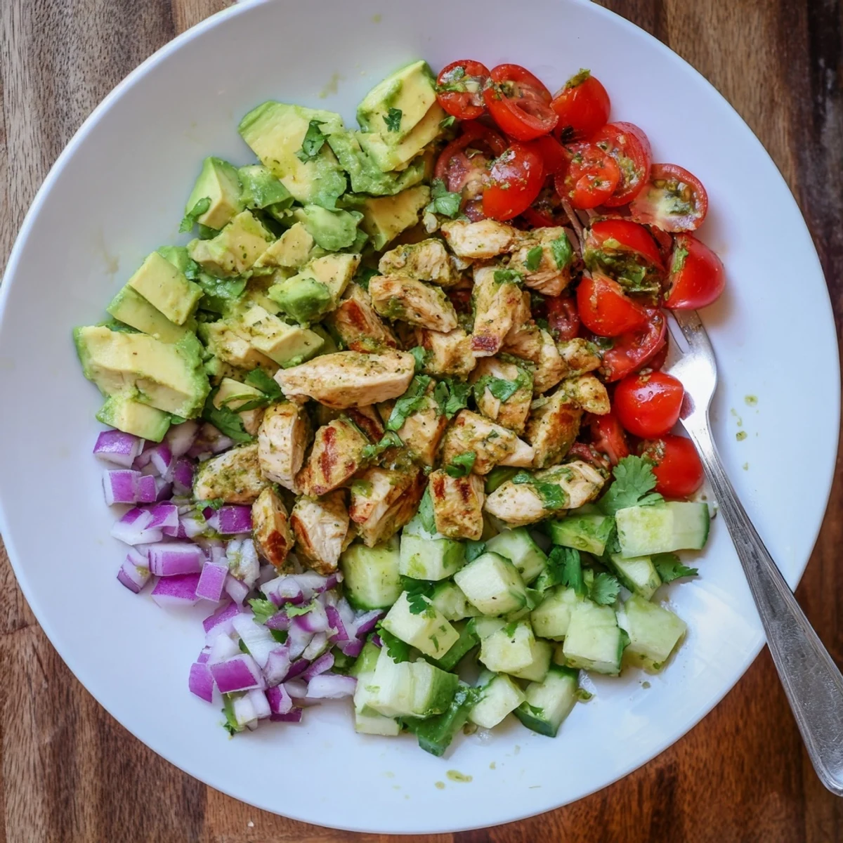 Healthy avocado chicken salad plated over mixed greens, perfect for a gluten-free low carb lunch.