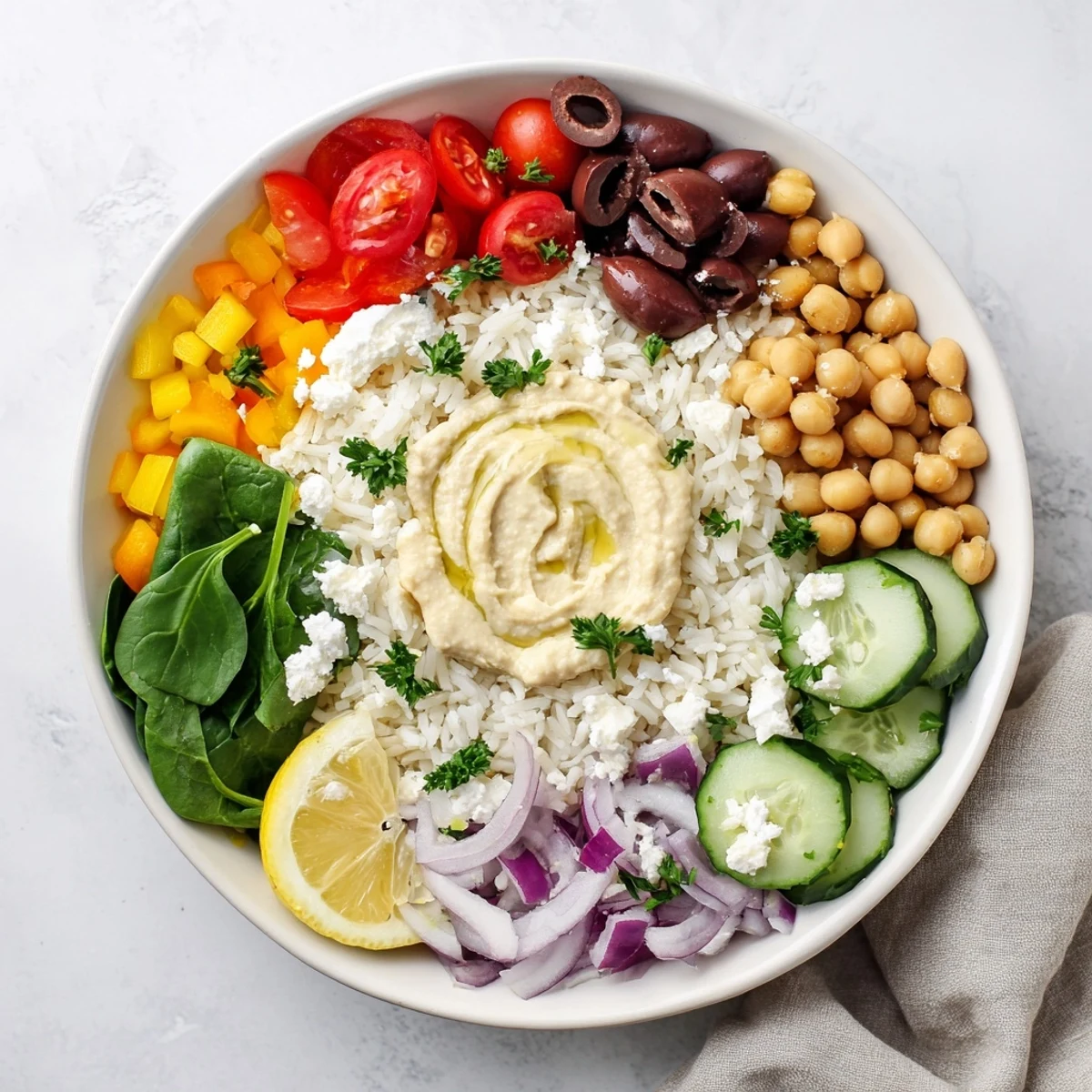 Fluffy rice base layered with crisp cucumbers, tomatoes, olives, and creamy feta in Mediterranean rice bowl