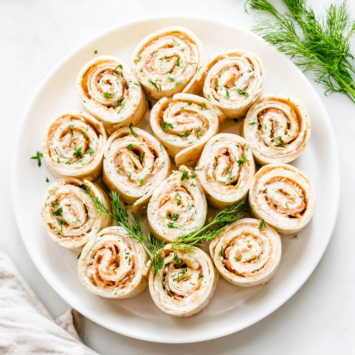 Tasty smoked salmon roll ups appetizer with fresh dill and chives arranged for elegant party presentation