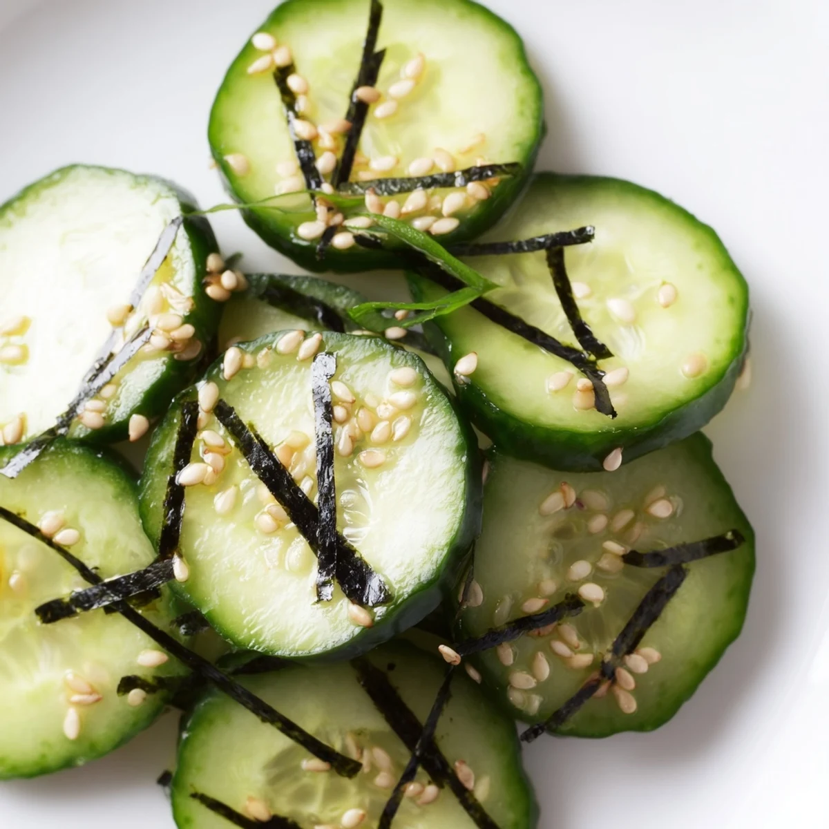 Refreshing sushi cucumber salad drizzled with sesame soy dressing in a white bowl