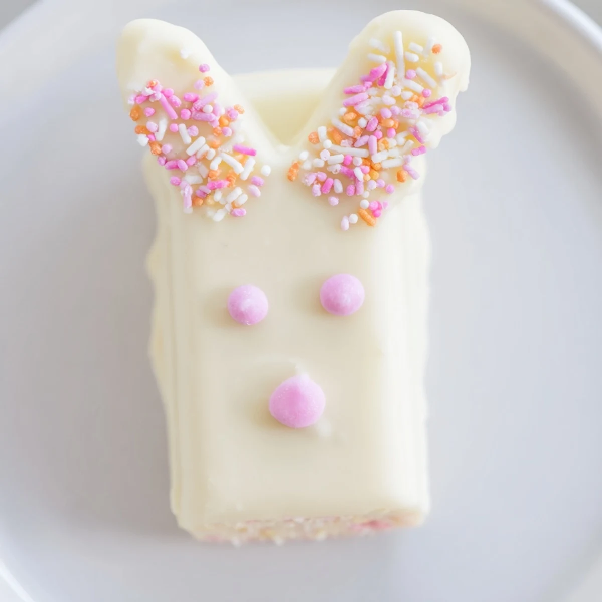 Creamy white chocolate bunny cakesicles decorated with sprinkles for a sweet Easter celebration