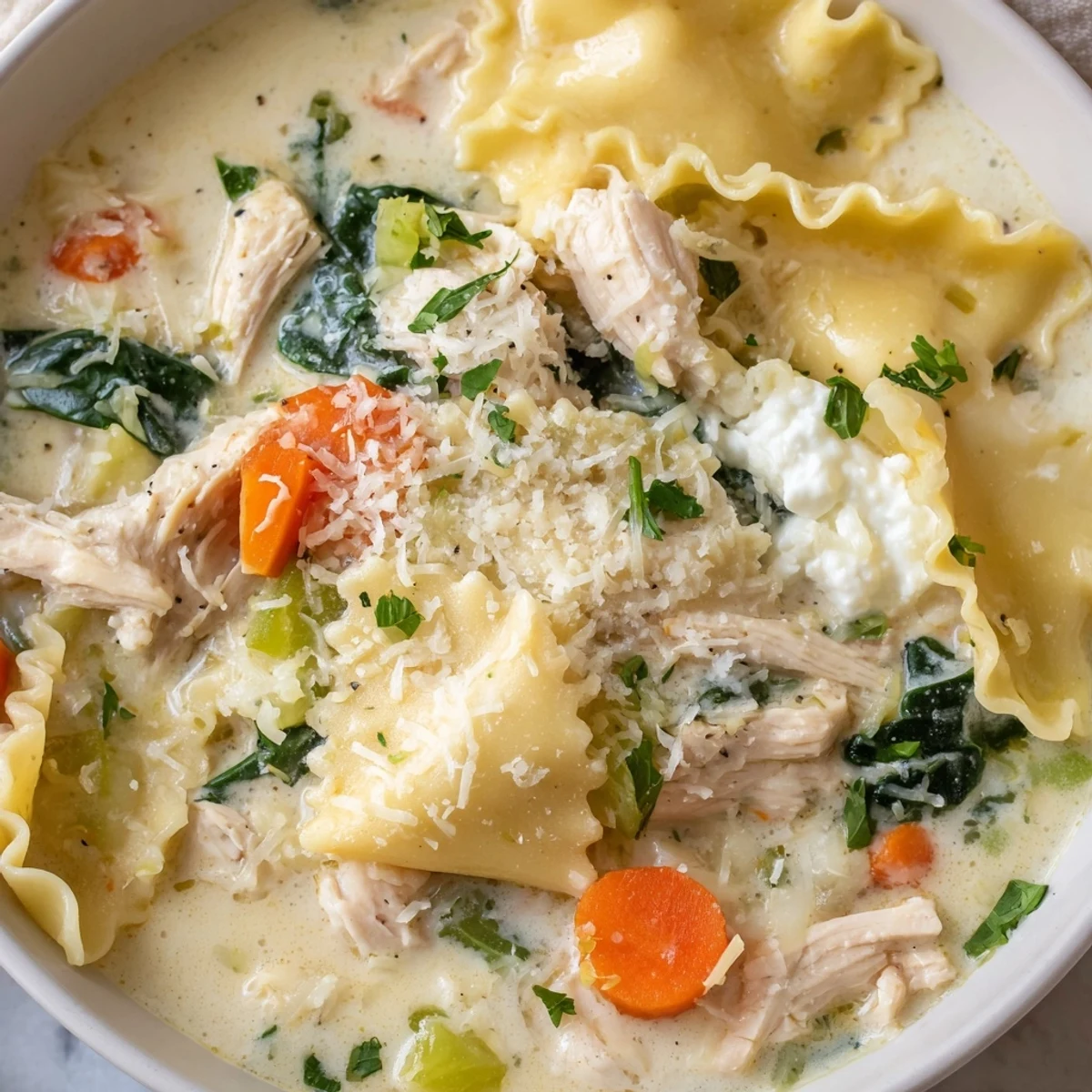 Steaming bowl of Italian white lasagna soup with tender chicken, spinach, and broken noodle pieces