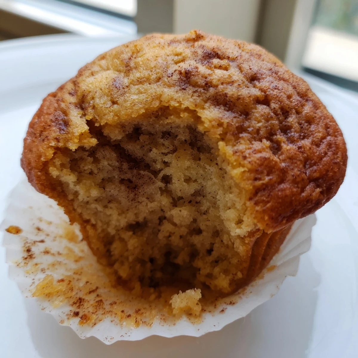 Golden banana muffins with crackly tops cooling on a wire rack