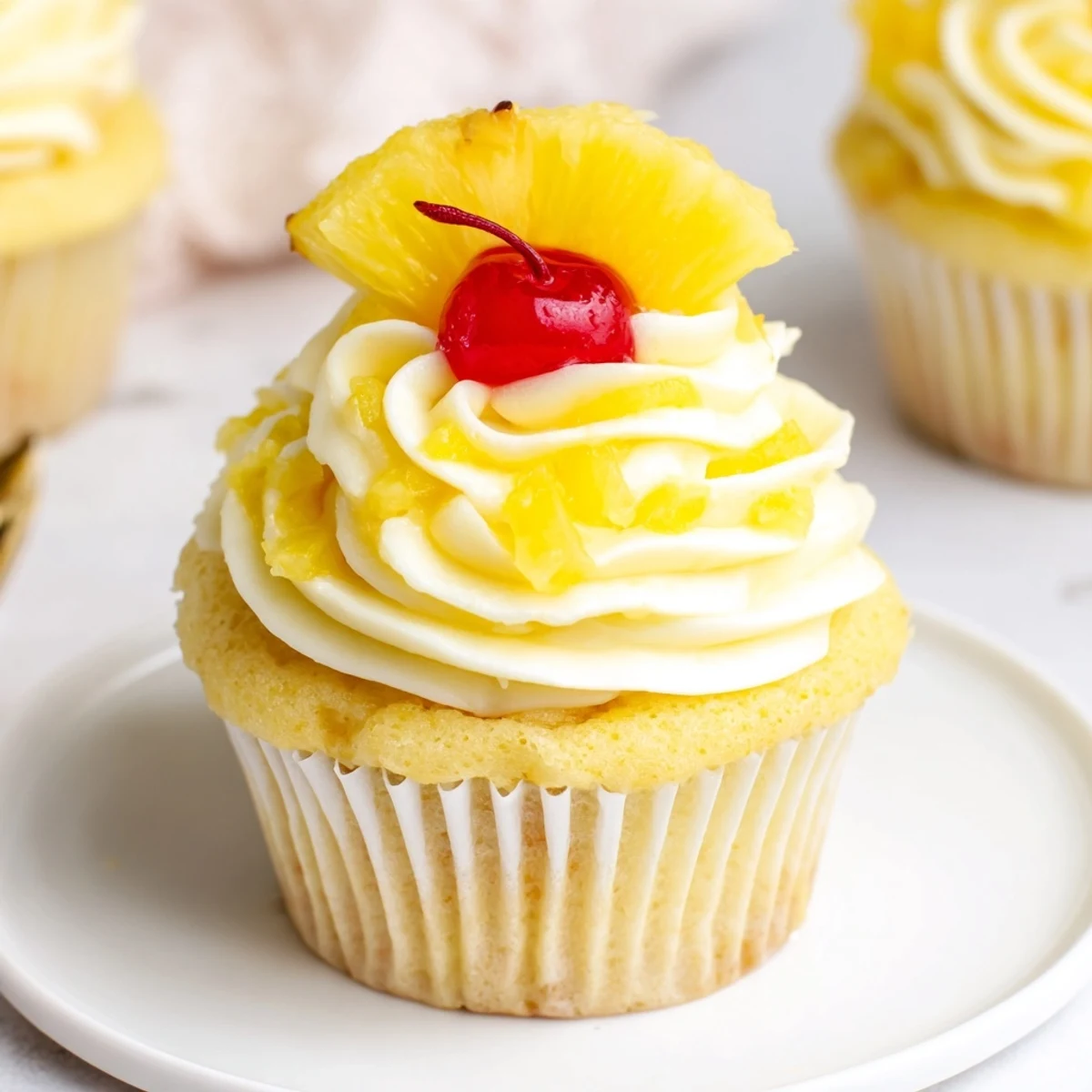 Creamy Dole Whip Cupcakes Recipe topped with maraschino cherry and tropical garnish.