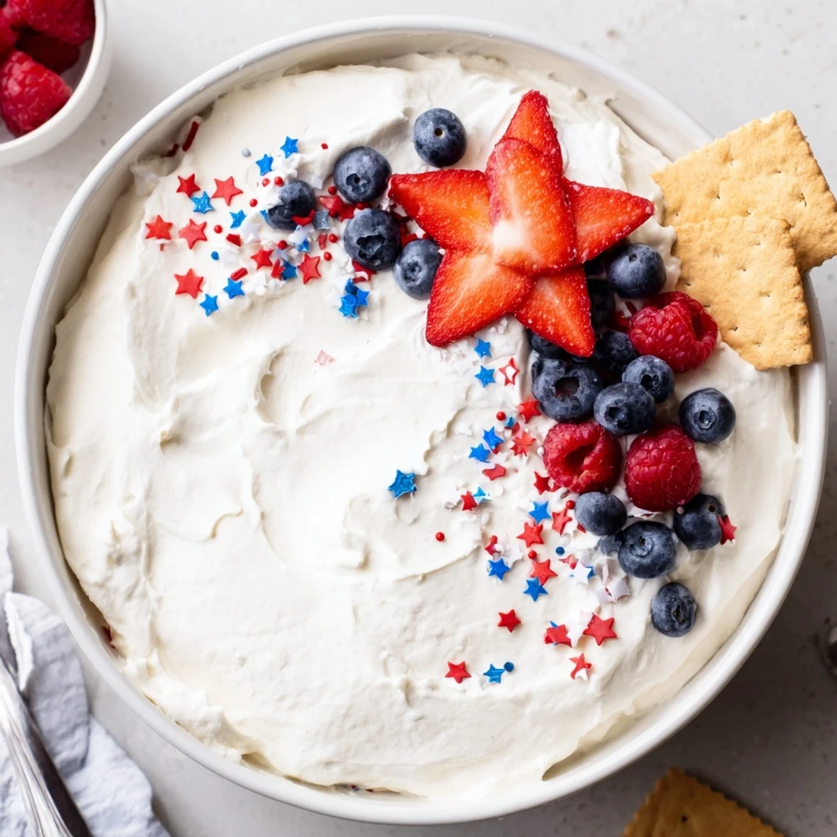 How to Make Star Spangled Cheesecake Dip displayed with graham crackers and pretzels