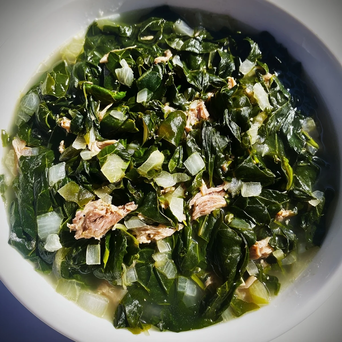 Vibrant green collard greens cooked until meltingly tender in a rich pot with savory seasonings and broth.