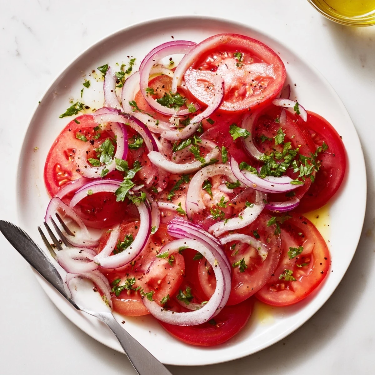 Colorful tomato and onion salad plated with red onion rings and vibrant parsley garnish