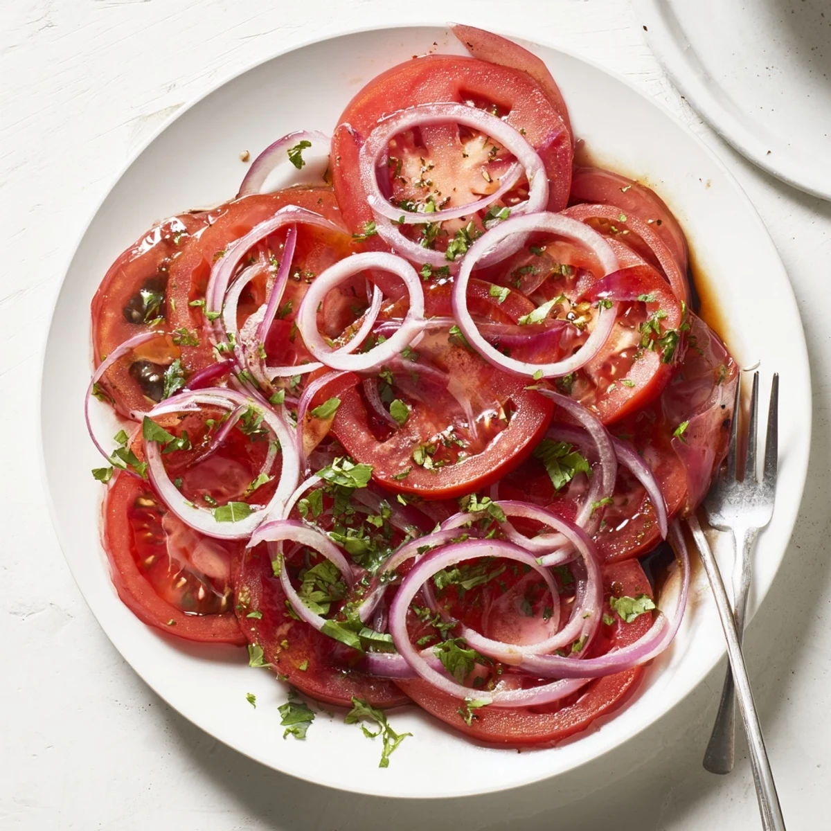 Mediterranean-style tomato and onion salad marinated in olive oil dressing for refreshing summer dining