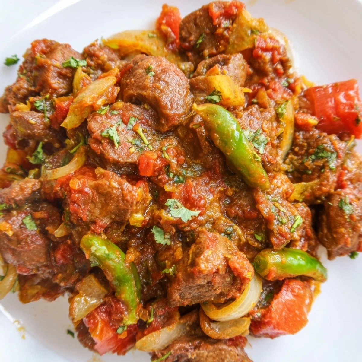 Tender Kenyan goat wet fry with chunks of meat simmered in rich tomato onion sauce