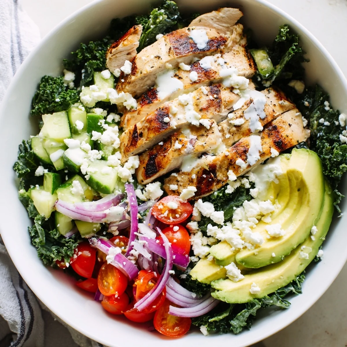 Nourishing protein-packed bowl featuring grilled marinated chicken breast over crisp kale and colorful vegetable toppings