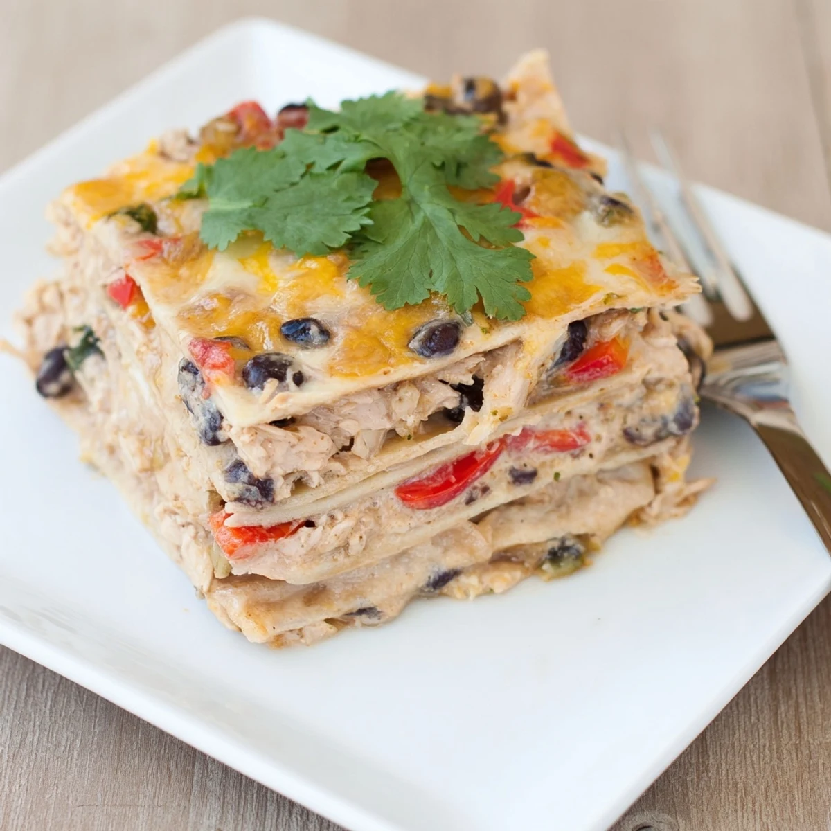 Sliced creamy chicken taco lasagna showing tender chicken layers and gooey cheese