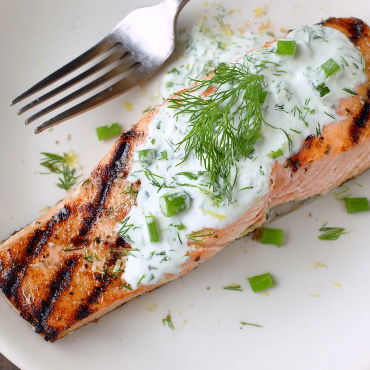 Perfectly grilled salmon with bright lemon herb marinade drizzled with cool cucumber dill yogurt sauce