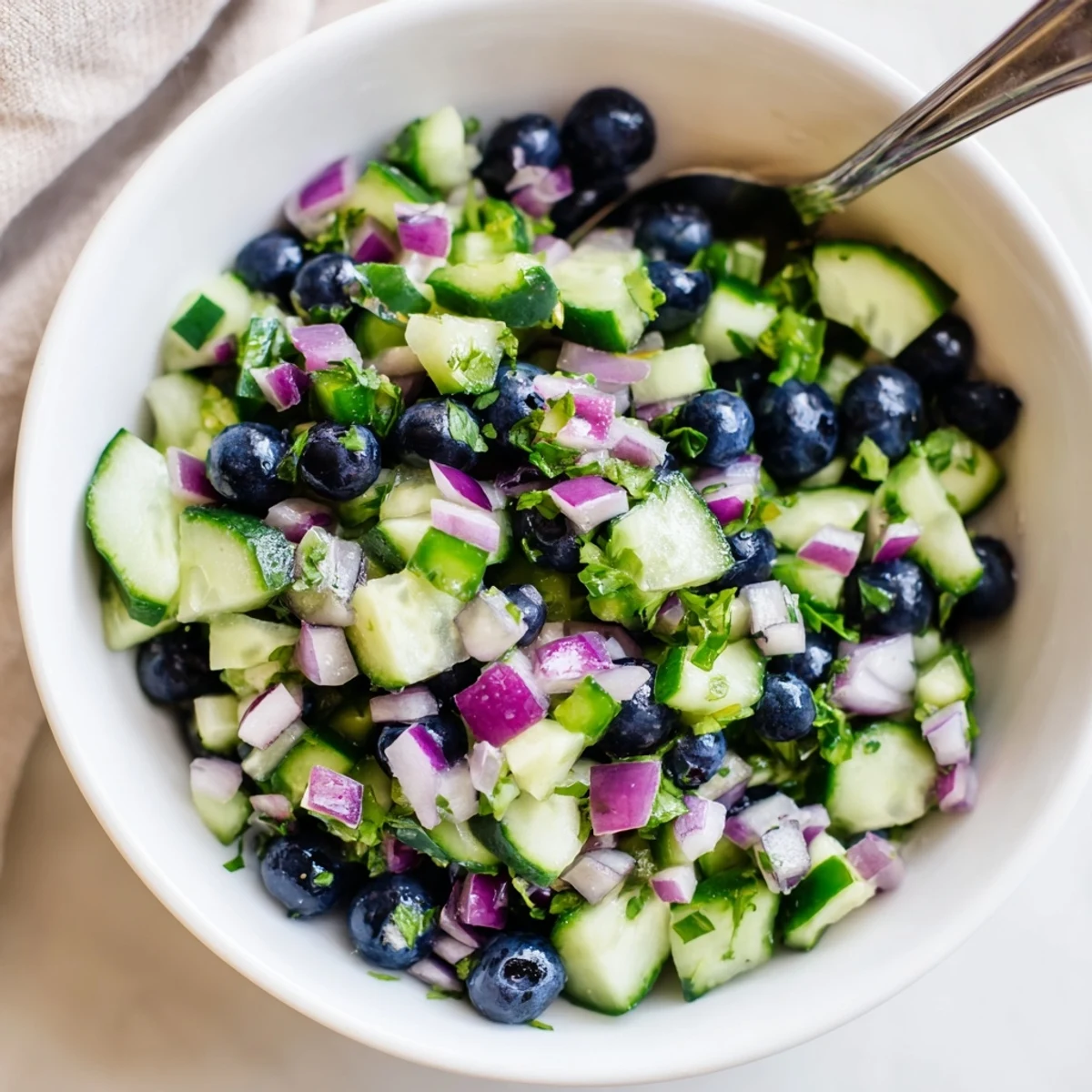 Close-up of fresh blueberry cucumber salsa spooned onto a crispy tortilla chip