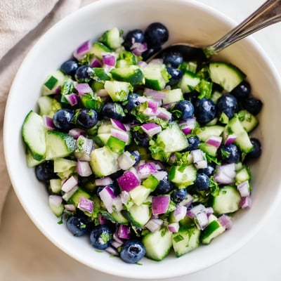 Close-up of fresh blueberry cucumber salsa spooned onto a crispy tortilla chip